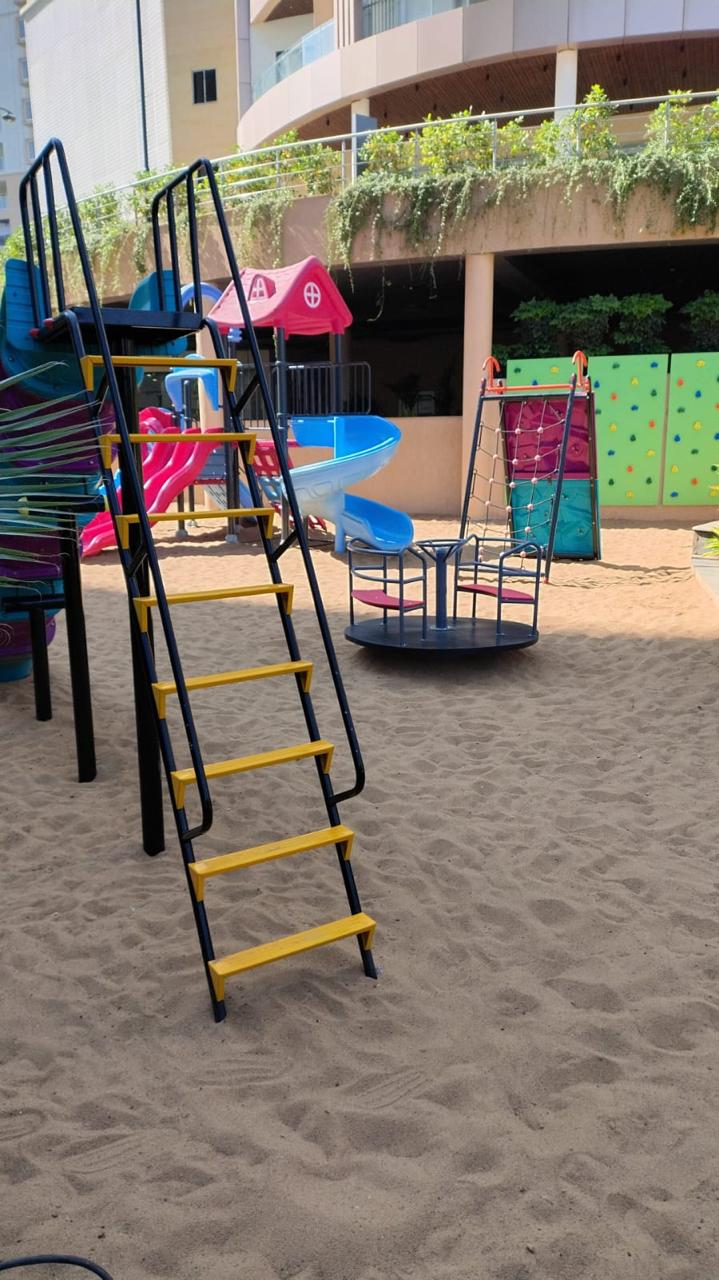 The outdoor play area with climbing frame and sand pit