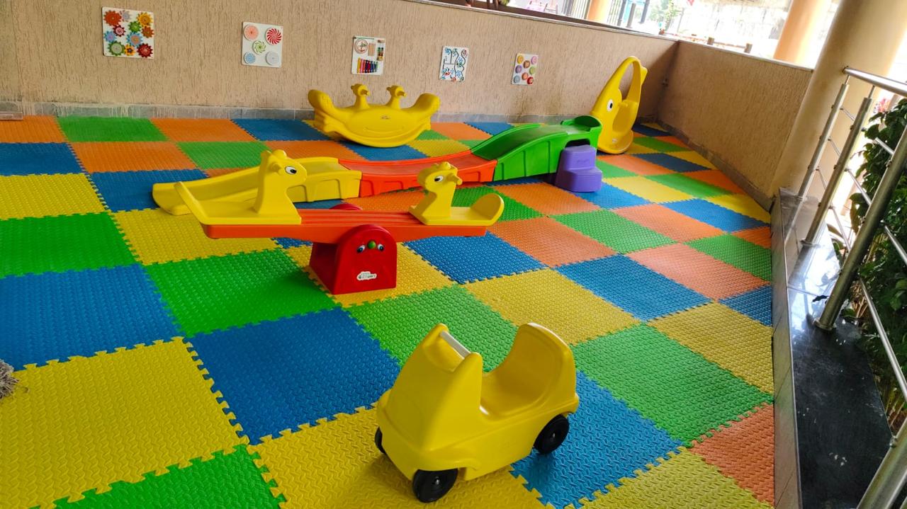 The indoor play area with soft mats, see-saws and ride-on toys